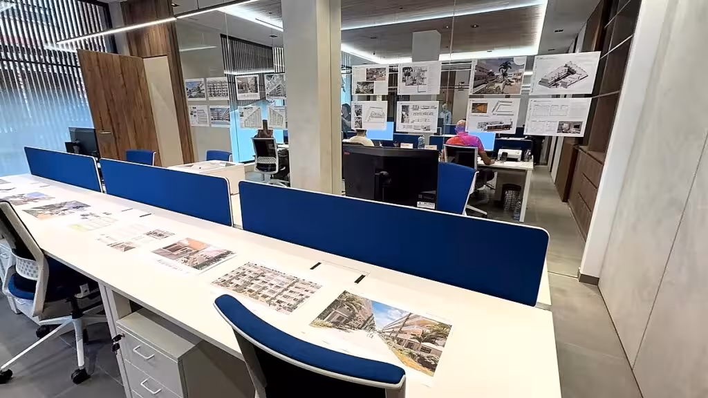 Büro mit Beratungstischen, blauen Trennwänden und ausgestellten Wohnungsprojekten