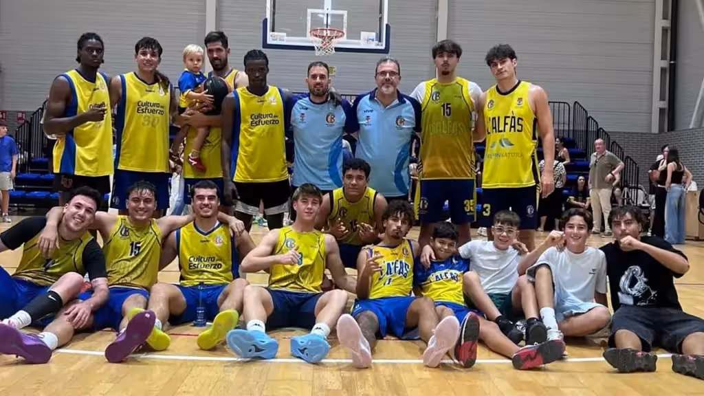 A group in basketball kit poses on an indoor court
