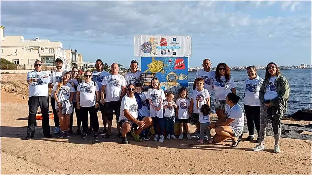 Freiwillige der Reinigungsaktion am Meer mit einem Banner der Initiative