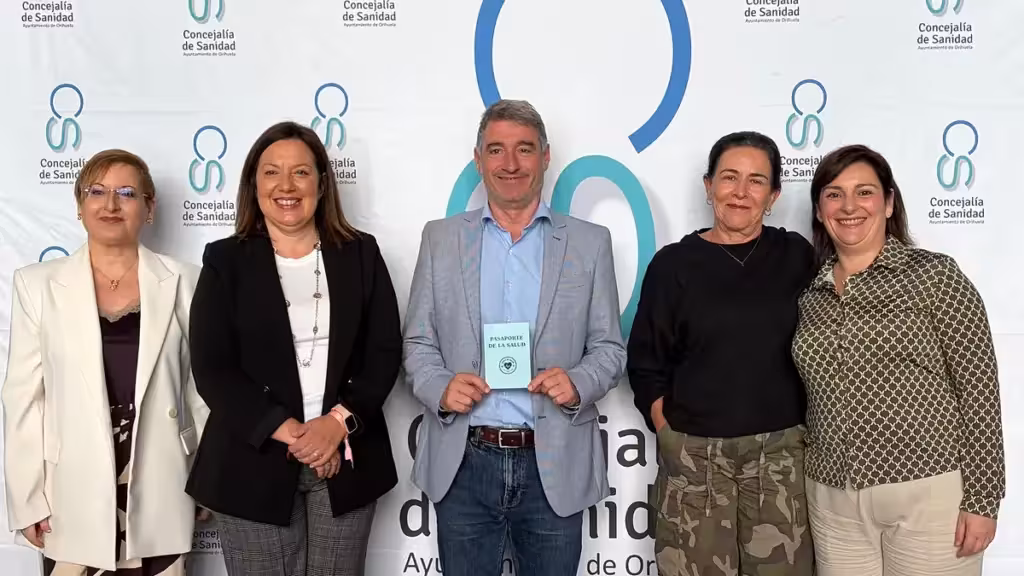 Fünf Personen vor einer Kulisse des Gesundheitsressorts von Orihuela; eine hält den Gesundheitspass.