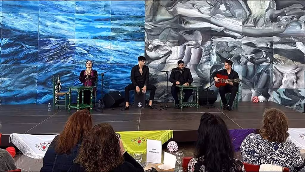 Cuatro intérpretes sentados en el escenario durante una actuación de cante y guitarra flamenca, ante público en el Auditorio Internacional