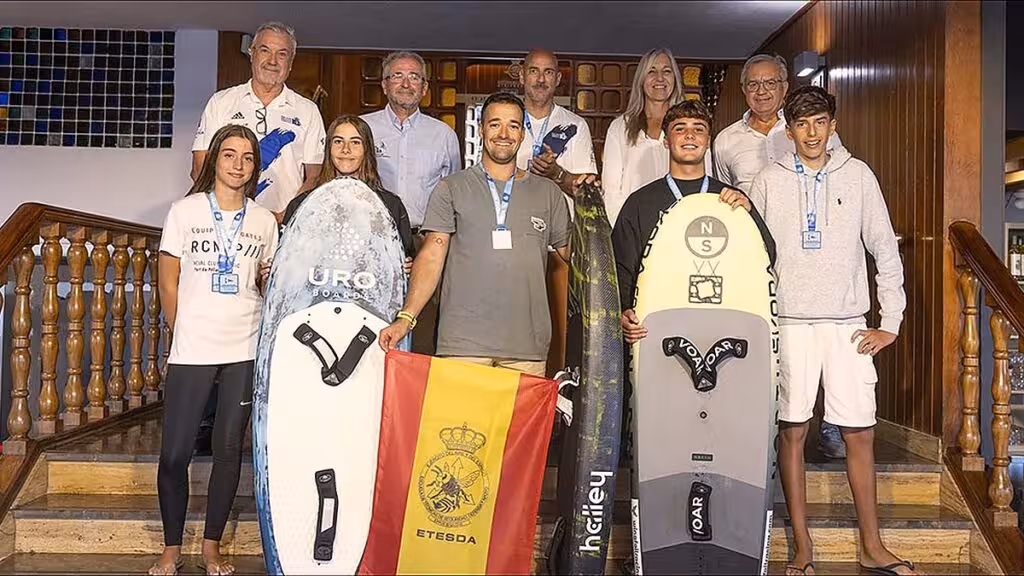 Participantes y representantes posan con tablas y medallas en el club náutico