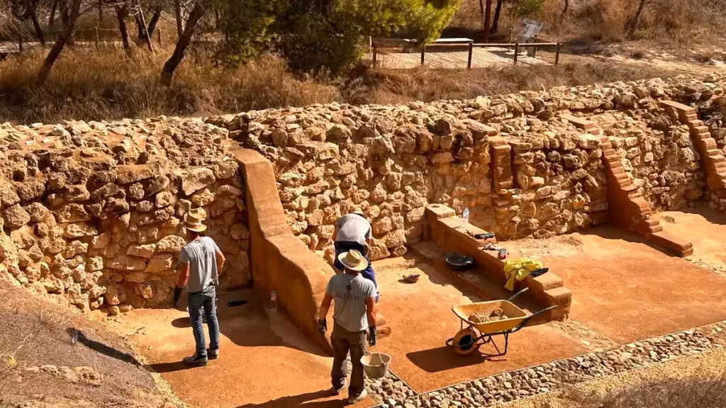 Work beside stone structures at the La Fonteta archaeological site in Guardamar
