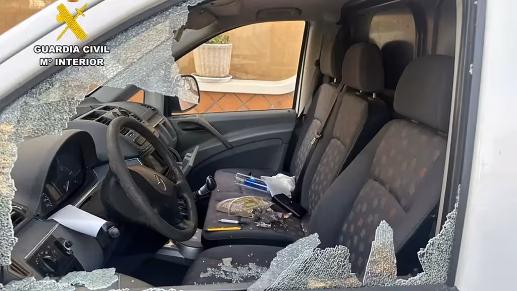 Ventanilla lateral rota y habitáculo de un vehículo estacionado
