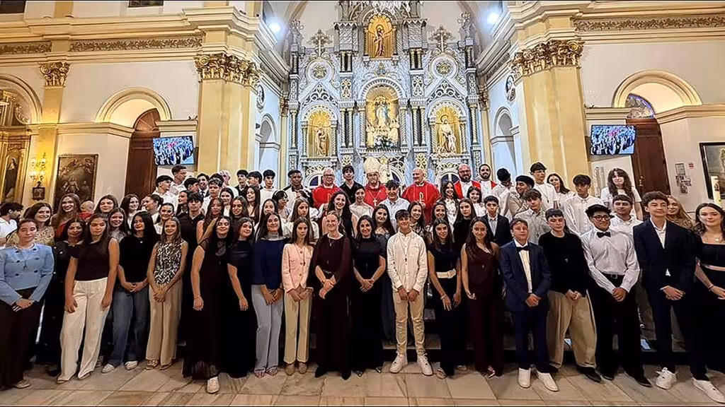 Grupo de asistentes posa ante el altar de una iglesia tras una celebración