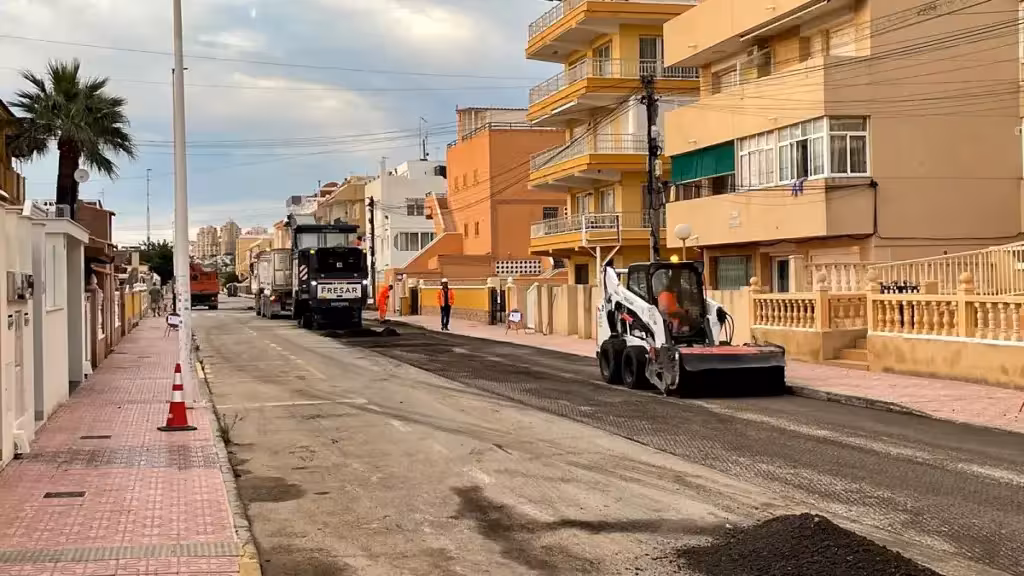 Maquinaria y operarios retiran el pavimento de una calle residencial durante los trabajos de reasfaltado en La Mata