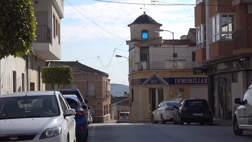 Calle de Torremendo con edificios y vehículos estacionados