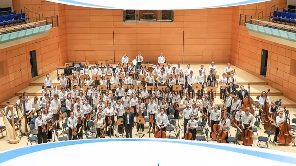 Fotografía de una orquesta sobre un escenario utilizada en el cartel del concierto de Palau Altea