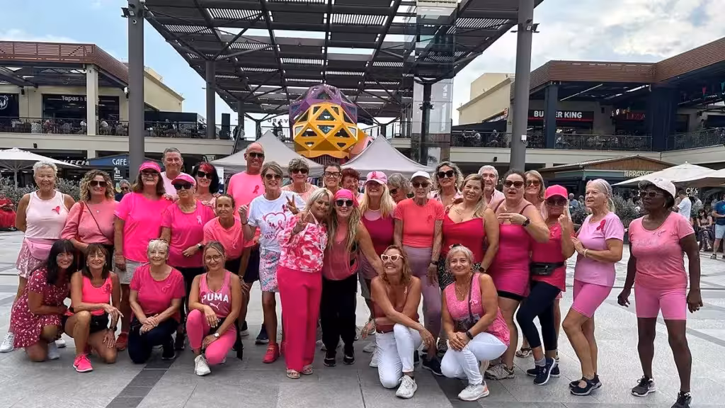 Gruppe in rosafarbener Kleidung beim gemeinsamen Foto im Zenia Boulevard während der Brustkrebs-Aufklärungsaktion
