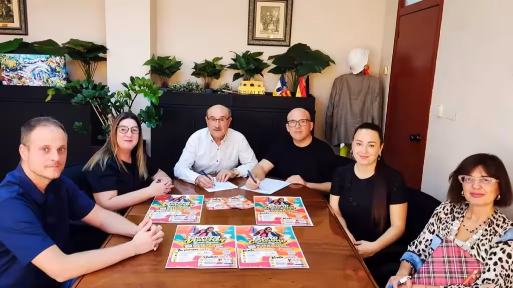 rojales-bono-consumo-venta-presencial-mayores-55-octubre-2026-es Personas reunidas en torno a una mesa con documentos y carteles de la campaña Bono Consumo de Rojales