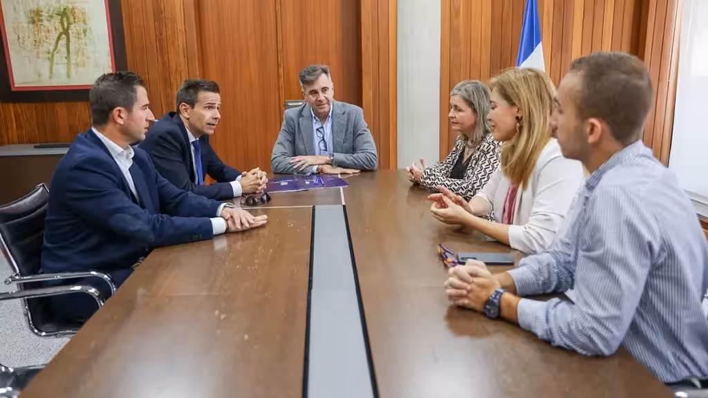 San Pedro del Pinatar firma una línea de un millón en microcréditos para emprendedores Seis personas reunidas alrededor de una mesa durante el encuentro sobre el convenio de microcréditos
