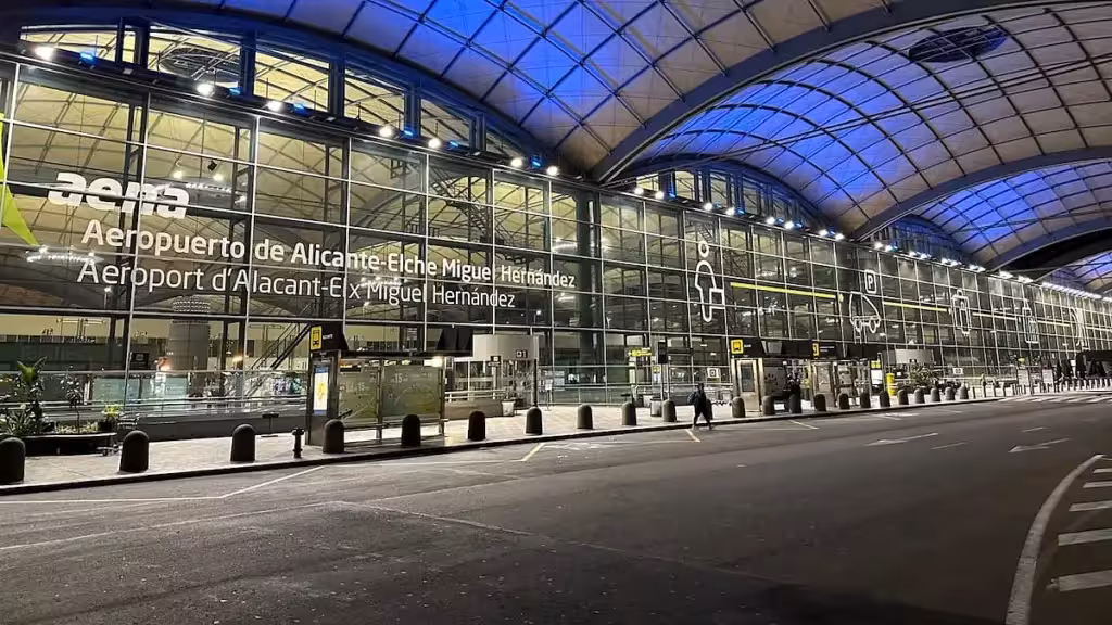Fachada iluminada de la terminal del aeropuerto de Alicante-Elche durante la noche
