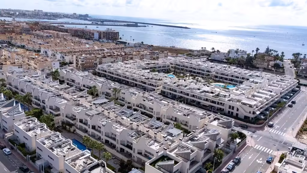 Vista aérea de la parte ya urbanizada de Villa Amalia, con viviendas, piscinas y el litoral al fondo.